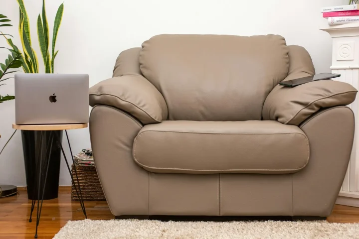 Oversized leather armchair next to a laptop on a side table