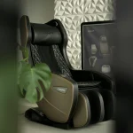 Black massage chair beside a houseplant